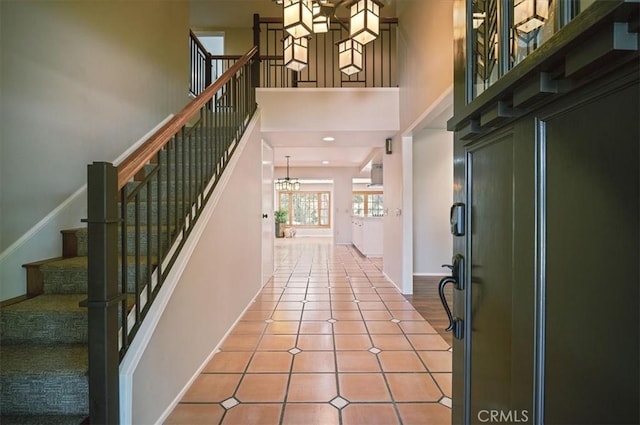 2521 Wildrose Ln, Upland, CA 91784 - foyer featuring a chandelier, a high ceiling, tile patterned flooring, and stairs
