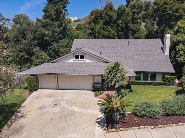 2521 Wildrose Ln, Upland, CA 91784 - view of front of house with driveway, an attached garage, a chimney, roof with shingles, and board and batten siding