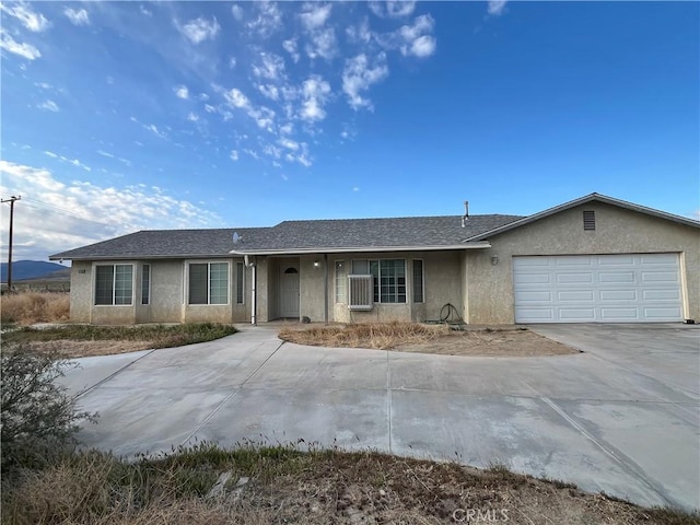 single story home featuring stucco siding, concrete driveway, and a garage
