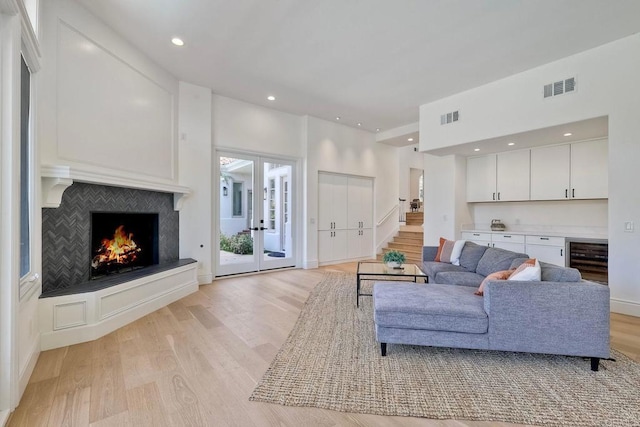 6039 Calle Camposeco, Rancho Santa Fe, CA 92067 - living room featuring light wood-type flooring, a bar, wine cooler, a lit fireplace, and recessed lighting