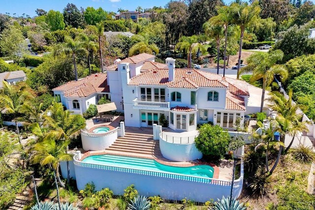 6039 Calle Camposeco, Rancho Santa Fe, CA 92067 - back of house with an in-ground hot tub, a tile roof, a balcony, an outdoor pool, and stucco siding