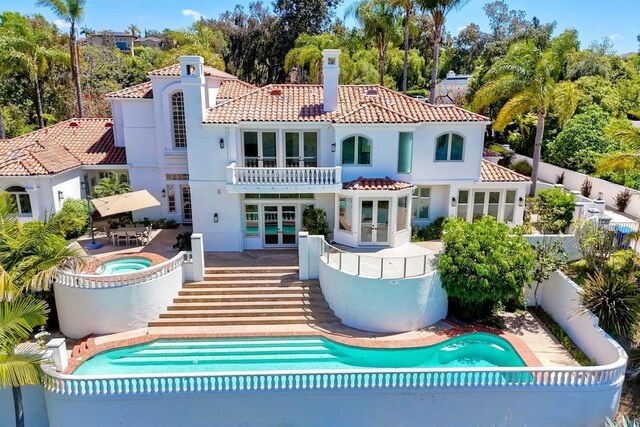 6039 Calle Camposeco, Rancho Santa Fe, CA 92067 - rear view of house with french doors, an outdoor hot tub, a tiled roof, a chimney, and an outdoor pool