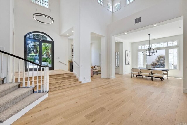 6039 Calle Camposeco, Rancho Santa Fe, CA 92067 - foyer featuring a towering ceiling, stairs, light wood finished floors, a chandelier, and baseboards