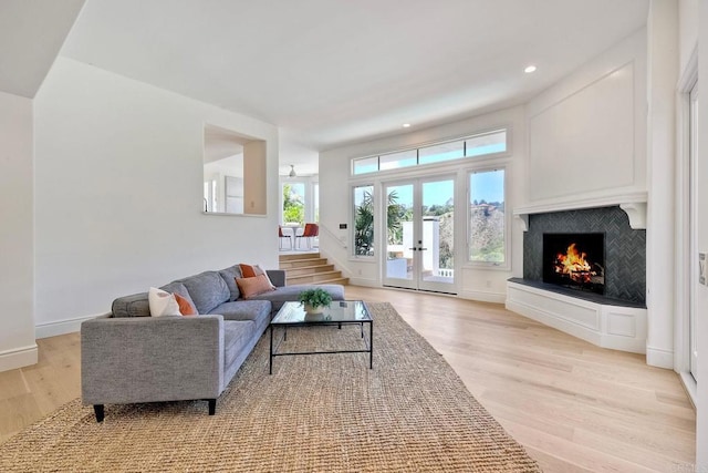6039 Calle Camposeco, Rancho Santa Fe, CA 92067 - living room featuring light wood finished floors, a lit fireplace, french doors, recessed lighting, and baseboards