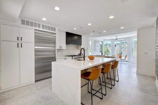 6039 Calle Camposeco, Rancho Santa Fe, CA 92067 - kitchen with stainless steel built in fridge, a kitchen island with sink, recessed lighting, a sink, and extractor fan