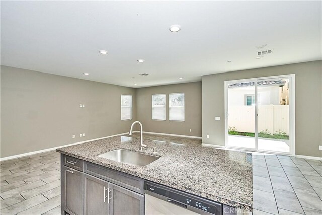 894 Harvest Ave, Upland, CA 91786 - kitchen featuring a sink, stainless steel dishwasher, open floor plan, light stone counters, and baseboards