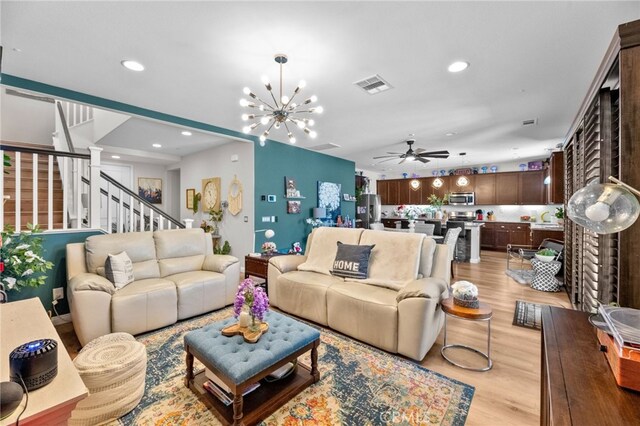36438 Geranium Dr, Lake Elsinore, CA 92532 - living room with a ceiling fan, recessed lighting, light wood finished floors, a chandelier, and stairs