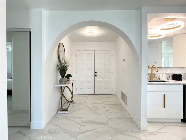 445 E San Rafael Dr, Palm Springs, CA 92262 - entrance foyer featuring light marble finish flooring, baseboards, and arched walkways