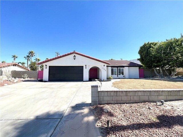 445 E San Rafael Dr, Palm Springs, CA 92262 - mediterranean / spanish-style home with a tile roof, stucco siding, fence, and an attached garage