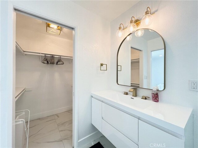 445 E San Rafael Dr, Palm Springs, CA 92262 - bathroom with marble finish flooring, vanity, a spacious closet, and baseboards