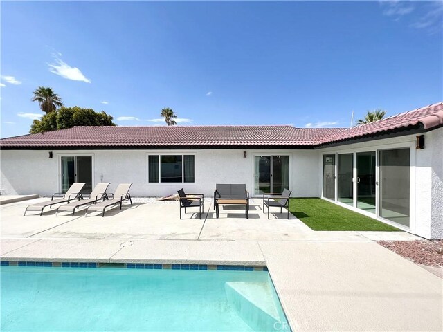 445 E San Rafael Dr, Palm Springs, CA 92262 - rear view of house featuring stucco siding, a tile roof, an outdoor pool, and a patio area