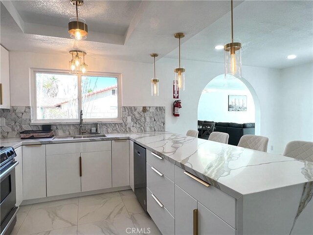 445 E San Rafael Dr, Palm Springs, CA 92262 - kitchen with a sink, a peninsula, appliances with stainless steel finishes, arched walkways, and white cabinetry