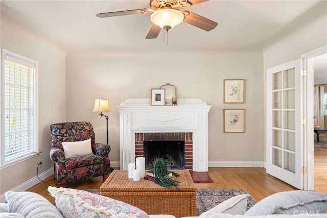 921 Arbutus Ave, Chico, CA 95926 - living room featuring wood finished floors, a ceiling fan, baseboards, and a brick fireplace