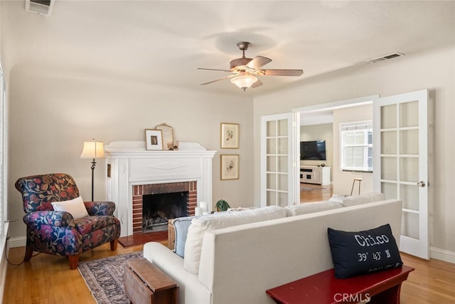 921 Arbutus Ave, Chico, CA 95926 - living area with wood finished floors, a ceiling fan, a brick fireplace, and baseboards