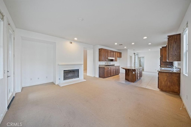 32475 Corte Barela, Temecula, CA 92592 - unfurnished living room with light colored carpet, recessed lighting, a glass covered fireplace, a sink, and baseboards