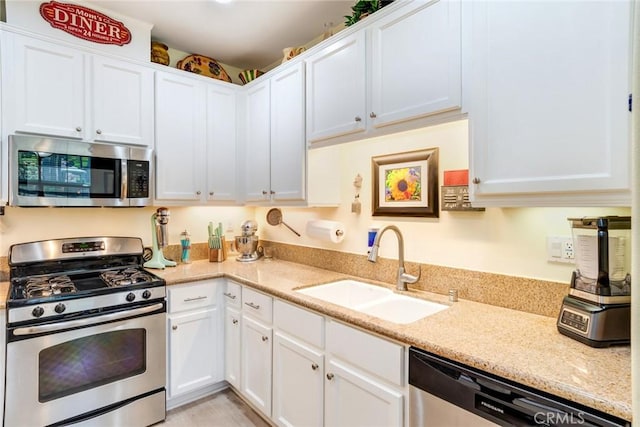 4329 Junction St Unit 103, Corona, CA 92883 - kitchen with appliances with stainless steel finishes, a sink, white cabinetry, and light stone counters