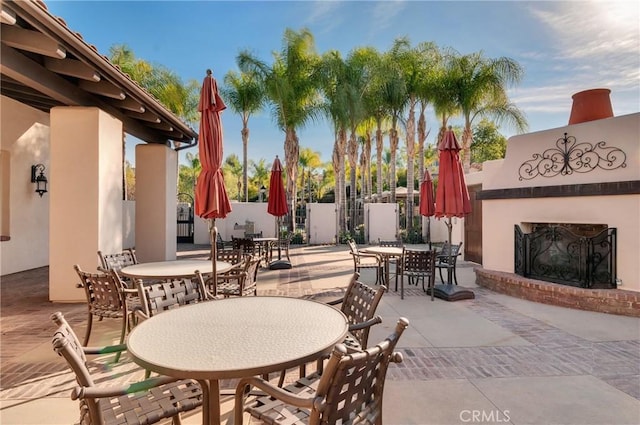 4329 Junction St Unit 103, Corona, CA 92883 - view of patio / terrace with outdoor dining space, an outdoor brick fireplace, and fence