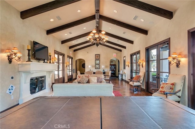 4329 Junction St Unit 103, Corona, CA 92883 - living area with arched walkways, a chandelier, beamed ceiling, a glass covered fireplace, and high vaulted ceiling