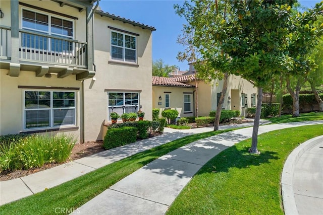 4329 Junction St Unit 103, Corona, CA 92883 - view of front facade featuring stucco siding, a tiled roof, a front yard, and a balcony