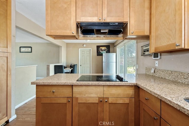 1030 Perrisito St, Perris, CA 92570 - kitchen featuring black electric stovetop, under cabinet range hood, a peninsula, wood finished floors, and light stone counters