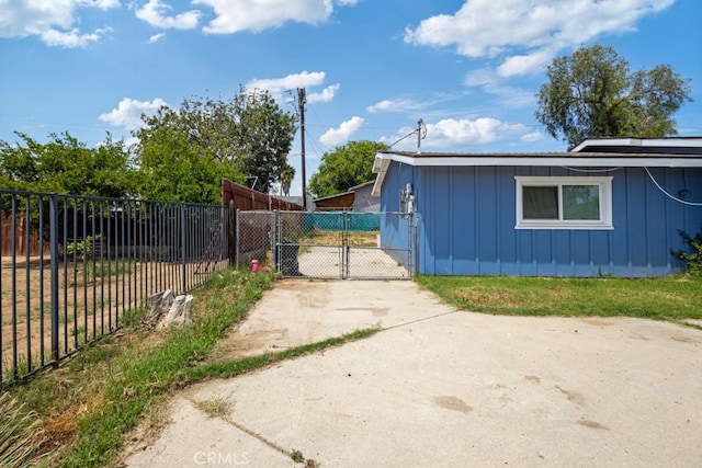 1030 Perrisito St, Perris, CA 92570 - view of side of home featuring board and batten siding, fence, and a gate