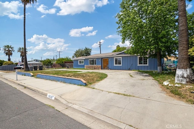 1030 Perrisito St, Perris, CA 92570 - view of front facade featuring board and batten siding, a front yard, and concrete driveway