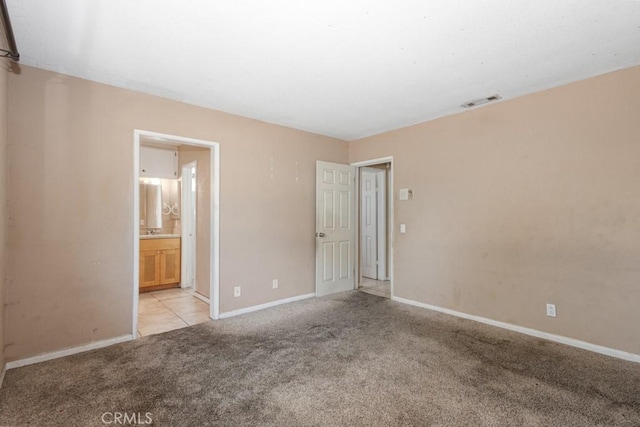 1030 Perrisito St, Perris, CA 92570 - unfurnished bedroom with light colored carpet, baseboards, and ensuite bath