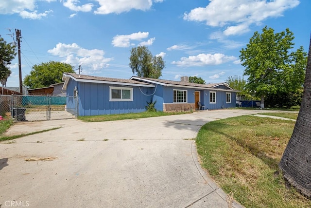 1030 Perrisito St, Perris, CA 92570 - ranch-style house featuring board and batten siding, concrete driveway, fence, and a gate