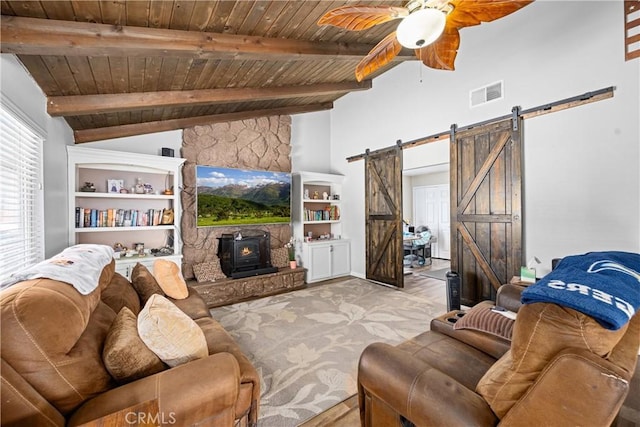19927 Athenon Ave, Perris, CA 92570 - carpeted living area featuring a wood stove, a barn door, wood ceiling, and ceiling fan
