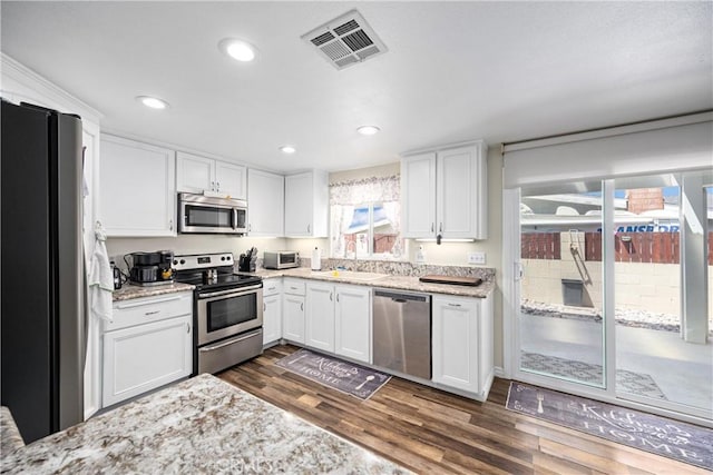 19927 Athenon Ave, Perris, CA 92570 - kitchen with stainless steel appliances, a sink, dark wood finished floors, white cabinetry, and recessed lighting