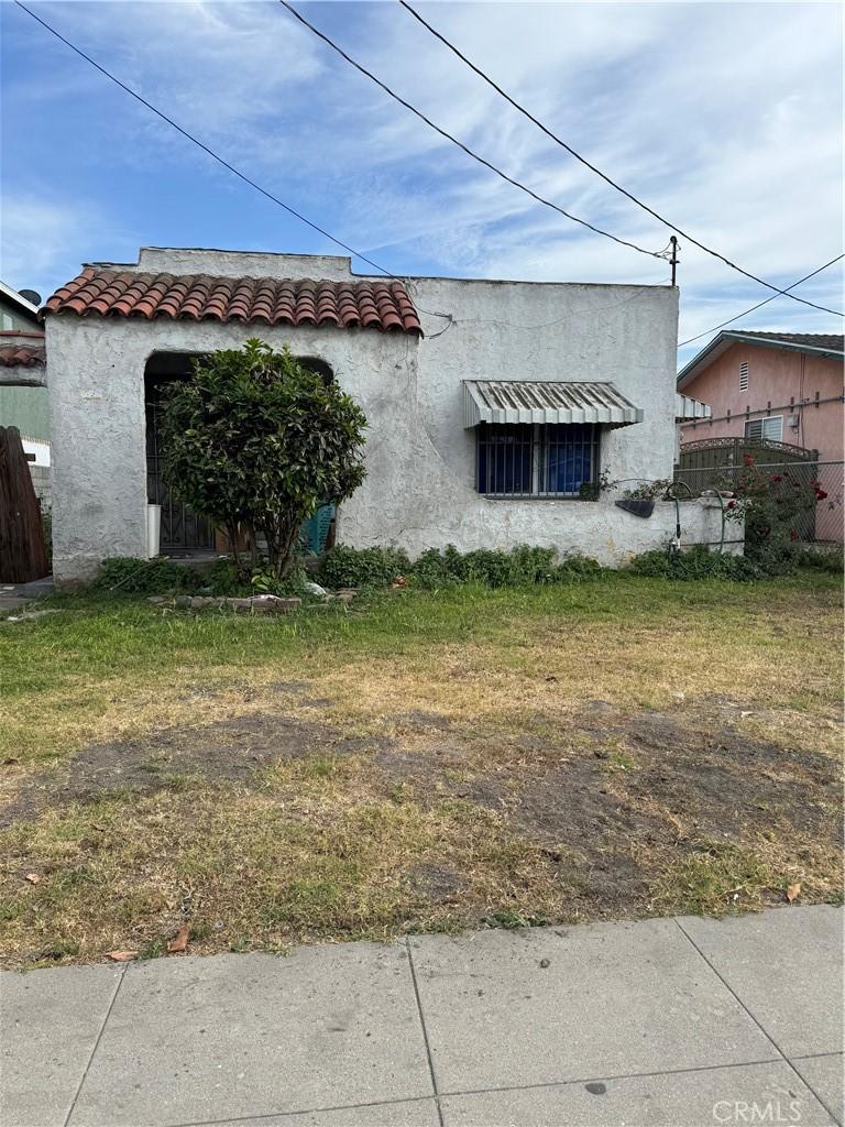 126 W 94th St, Los Angeles, CA 90003 - rear view of property featuring fence, a tile roof, and stucco siding