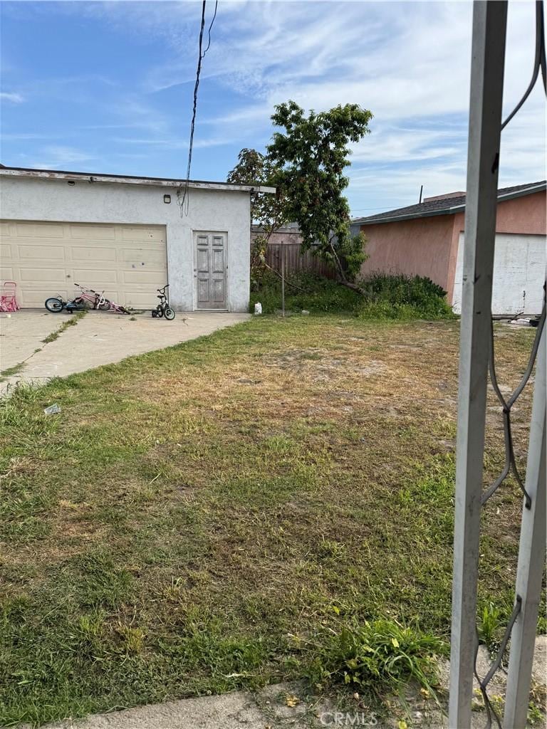 126 W 94th St, Los Angeles, CA 90003 - view of yard featuring a garage and an outbuilding