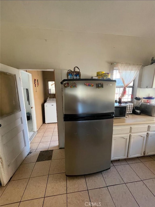 309 N Willowbrook Ave, Compton, CA 90220 - kitchen with freestanding refrigerator, washer / clothes dryer, light tile patterned floors, white cabinets, and light countertops