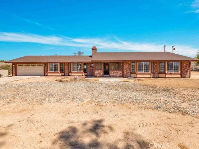 4689 Stirrup Ln Unit 29, Palms, CA 92277 - ranch-style house with a garage, driveway, a chimney, and brick siding