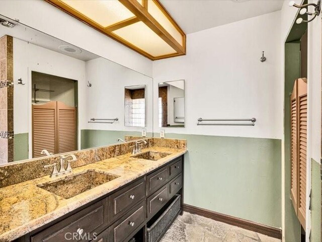 4689 Stirrup Ln Unit 29, Palms, CA 92277 - bathroom with baseboards, double vanity, and a closet