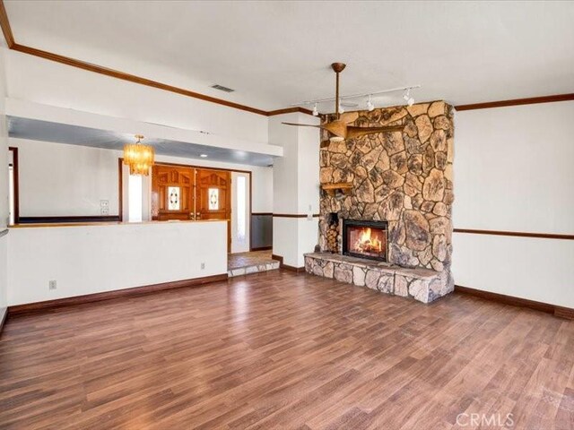4689 Stirrup Ln Unit 29, Palms, CA 92277 - unfurnished living room with track lighting, ornamental molding, baseboards, a fireplace, and wood finished floors