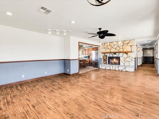 4689 Stirrup Ln Unit 29, Palms, CA 92277 - unfurnished living room with wood finished floors, ceiling fan, a fireplace, baseboards, and recessed lighting