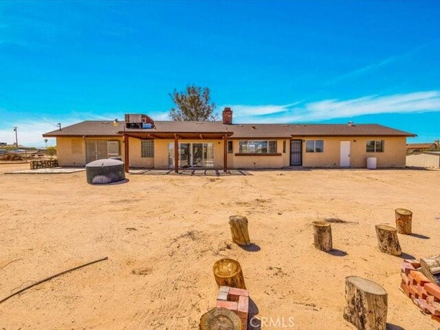4689 Stirrup Ln Unit 29, Palms, CA 92277 - rear view of property with a chimney