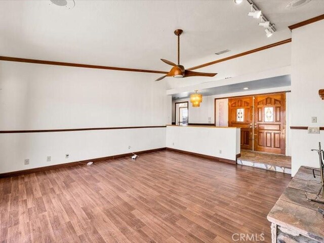 4689 Stirrup Ln Unit 29, Palms, CA 92277 - unfurnished living room featuring track lighting, ceiling fan, ornamental molding, wood finished floors, and baseboards