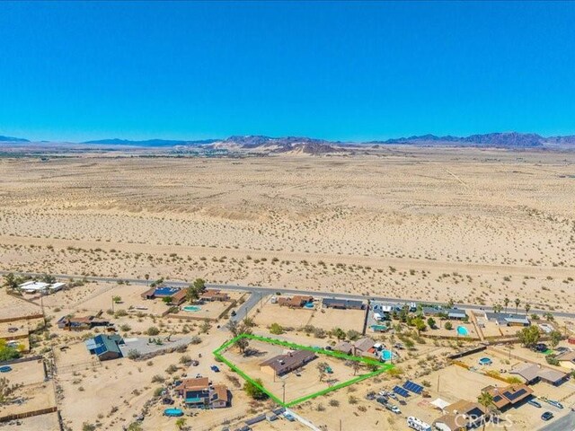 4689 Stirrup Ln Unit 29, Palms, CA 92277 - aerial view of sparsely populated area featuring a desert landscape, mountains, and property parcel outlined