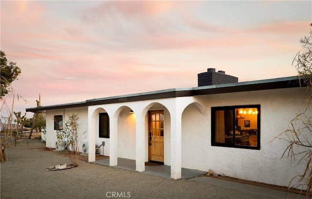 60515 Alta Loma Dr, Joshua Tree, CA 92252 - back of property at dusk with stucco siding and a chimney