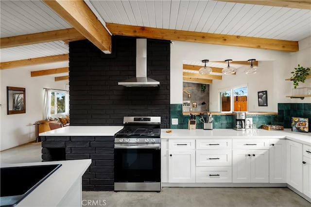 60515 Alta Loma Dr, Joshua Tree, CA 92252 - kitchen featuring stainless steel gas stove, wall chimney range hood, plenty of natural light, finished concrete floors, and beam ceiling