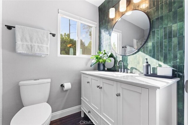 1421 Woodcrest Ave, Brea, CA 92821 - bathroom featuring double vanity, toilet, tasteful backsplash, baseboards, and wood finished floors