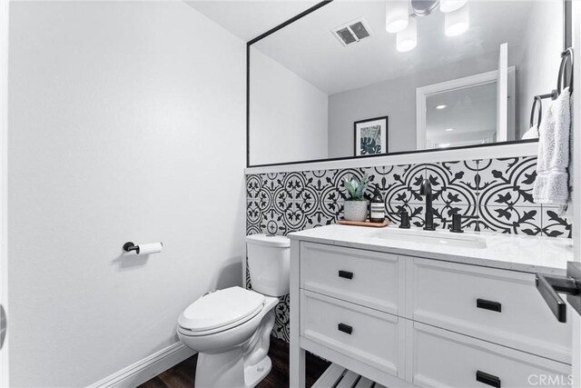 1421 Woodcrest Ave, Brea, CA 92821 - bathroom featuring vanity, toilet, backsplash, wood finished floors, and baseboards
