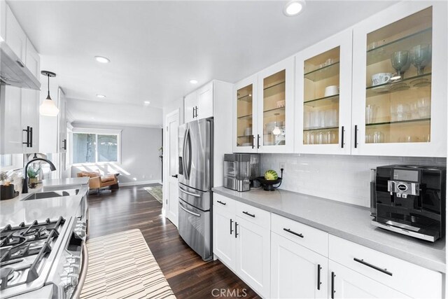 1421 Woodcrest Ave, Brea, CA 92821 - kitchen with stainless steel appliances, backsplash, a sink, white cabinetry, and baseboards