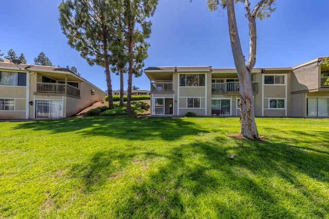 23342 Caminito Juanico Unit 304, Laguna Hills, CA 92653 - rear view of property featuring stucco siding and a yard