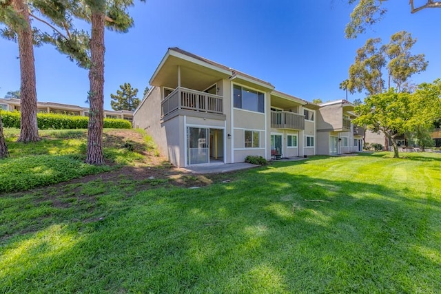 23342 Caminito Juanico Unit 304, Laguna Hills, CA 92653 - back of house featuring stucco siding, a lawn, and a balcony