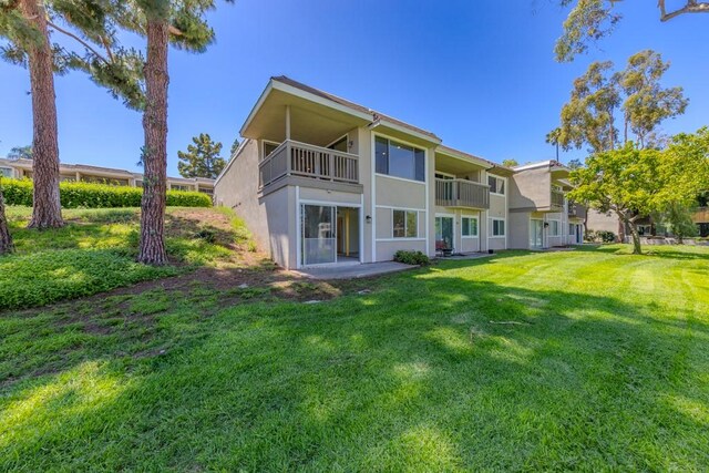 23342 Caminito Juanico Unit 304, Laguna Hills, CA 92653 - rear view of house with stucco siding, a yard, and a balcony