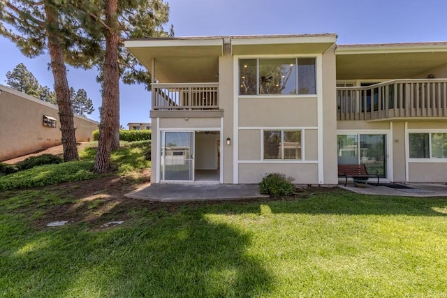 23342 Caminito Juanico Unit 304, Laguna Hills, CA 92653 - back of house with a balcony, a patio area, stucco siding, and a yard