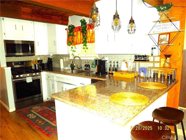33020 Arrowbear, Running Springs, CA 92382 - kitchen featuring appliances with stainless steel finishes, decorative backsplash, white cabinetry, dark wood finished floors, and a peninsula